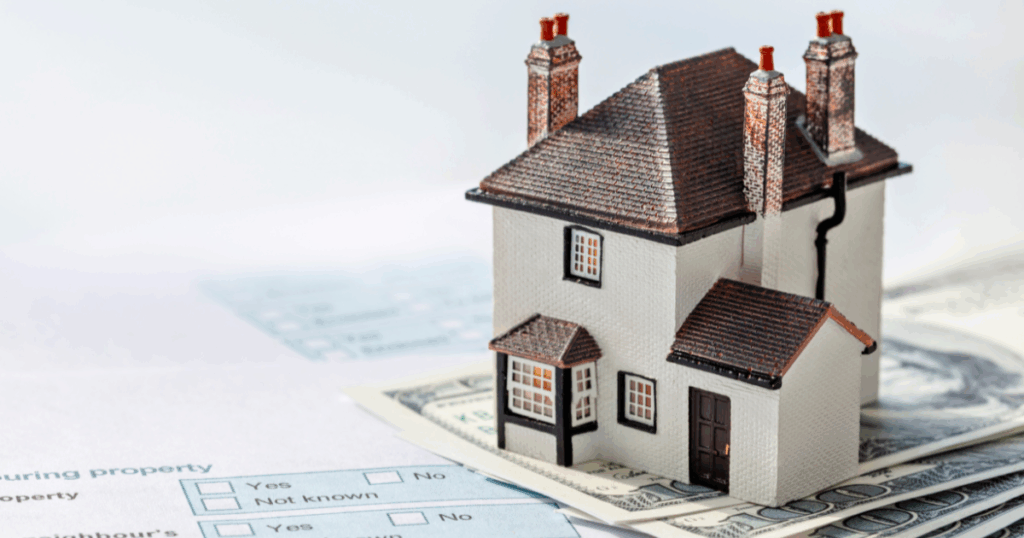 a dummy house on a piece of porpertyprice paper