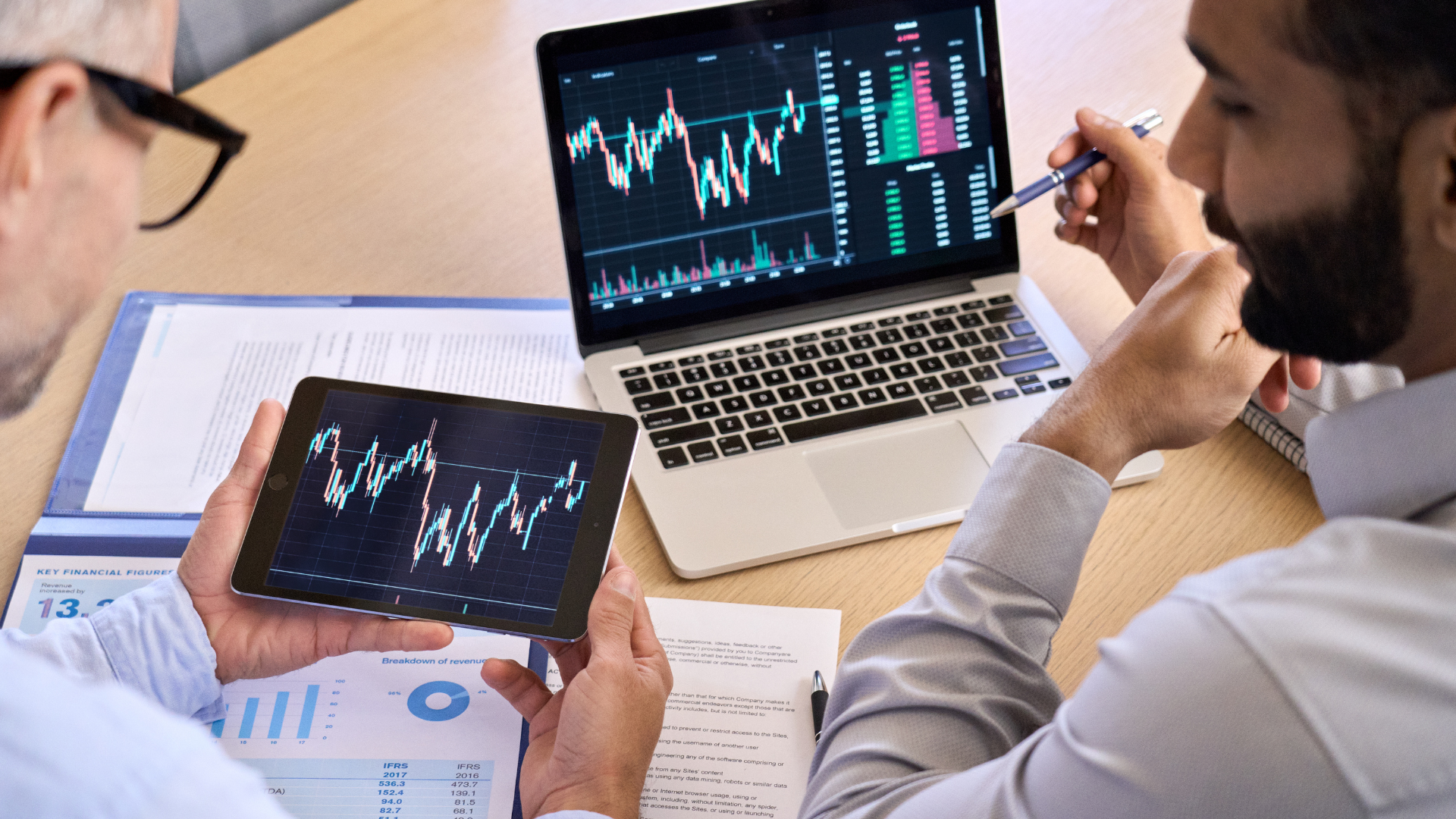 two men looking at charts and graphs digitally