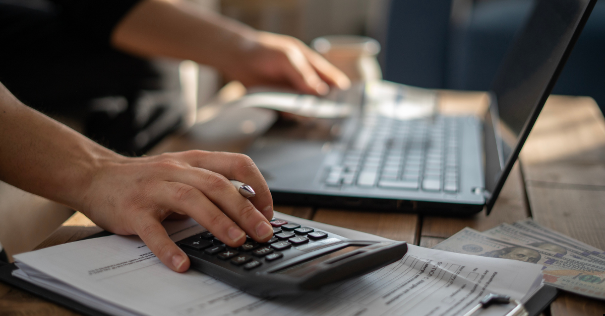 Buffer cost - wealth building through property where a man is calculating in calculator and laptop 