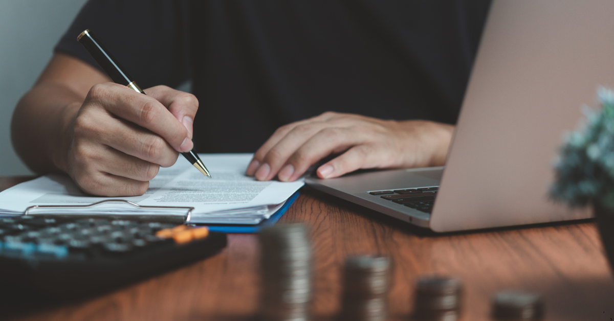 mortgage refinance rates - man using laptop, calculator and a pen for calculation