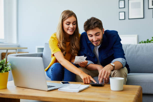 buying an apartment - couples looking at a calculator and calculating cost for buying an apartment in Sydney